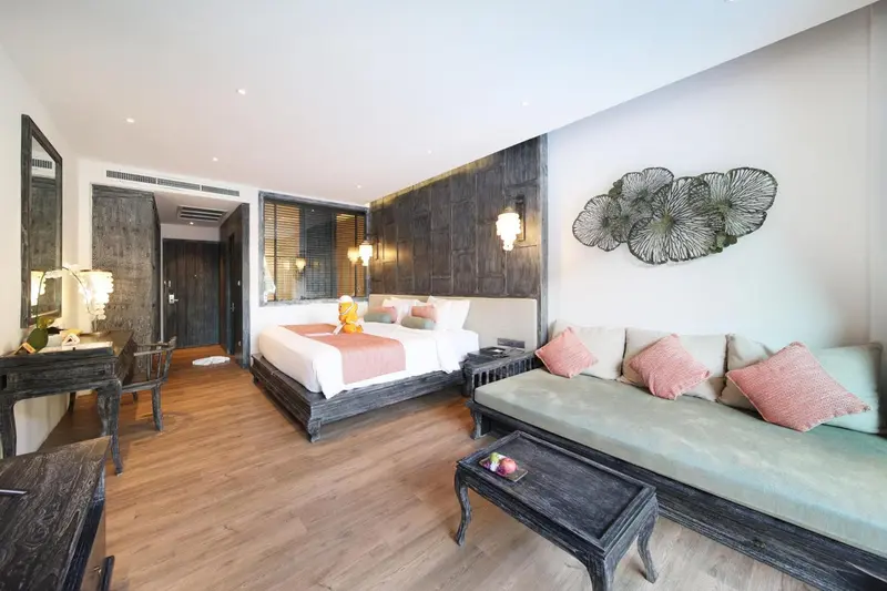 Une chambre lumineuse avec un grand lit et un coin salon.