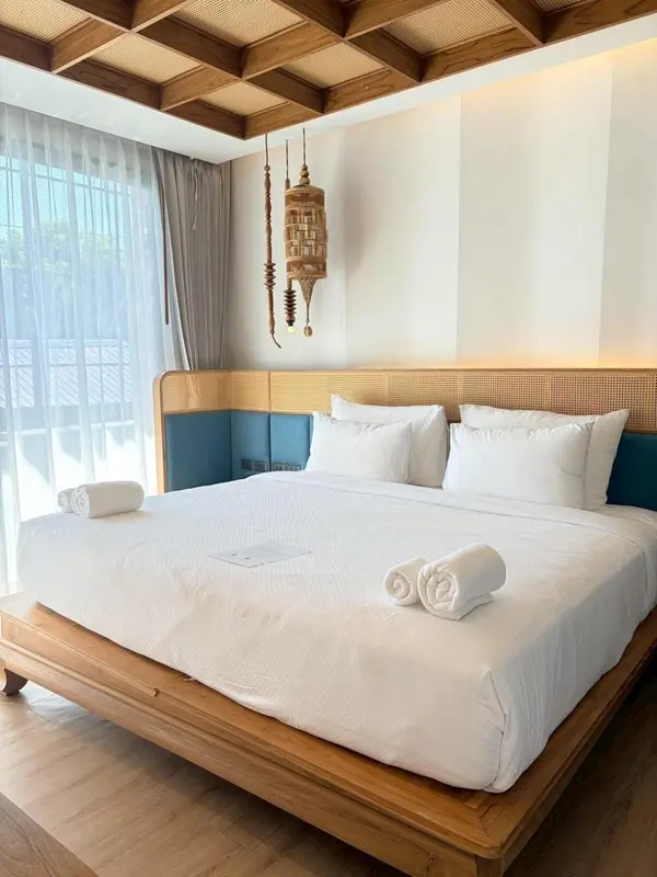 Une chambre lumineuse avec un grand lit recouvert de draps blancs.