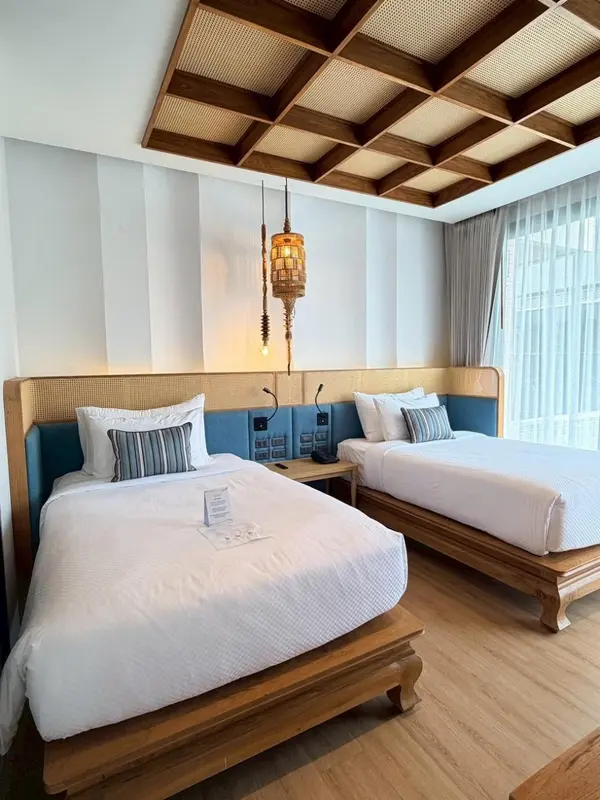 Chambre avec deux lits simples et décoration en bois.