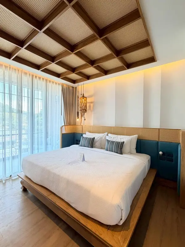 Une chambre lumineuse avec un grand lit et une décoration en bois.