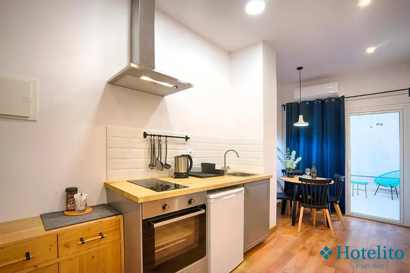 Une kitchenette lumineuse avec un plan de travail en bois et des ustensiles de cuisine.
