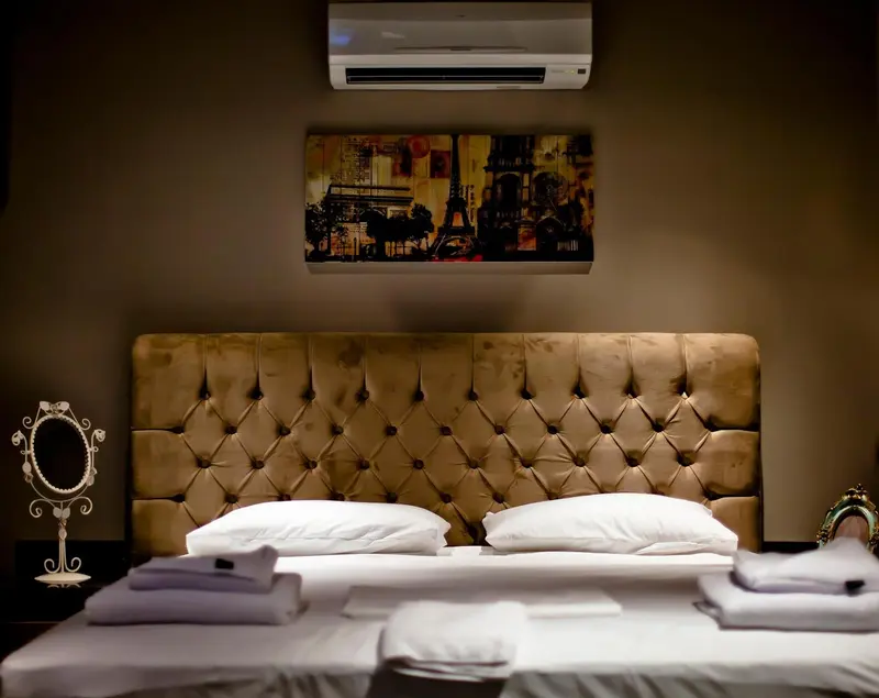 Une chambre avec un grand lit recouvert d'une courtepointe et de coussins blancs.