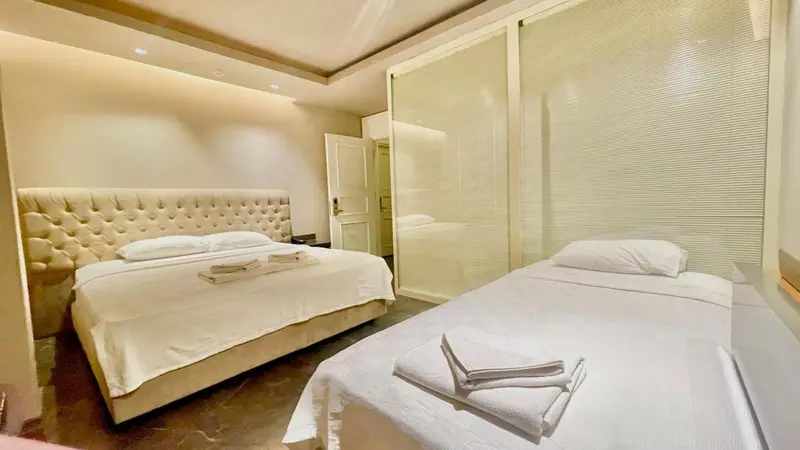 Une chambre avec deux lits et un grand miroir.
