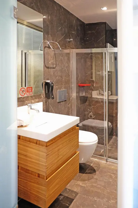 Une salle de bain moderne avec douche à l'italienne et meuble vasque en bois.
