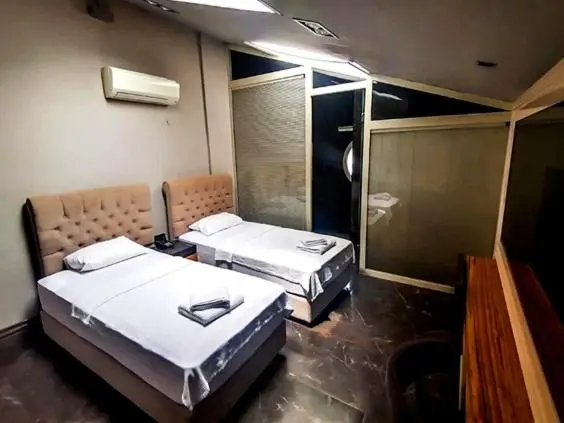 Une chambre avec deux lits simples et une décoration sobre.