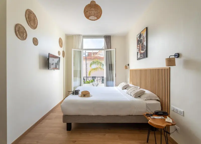 Une chambre lumineuse avec un grand lit et des décorations murales.