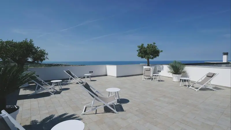 Terrasse aménagée avec chaises longues et vue sur la mer.
