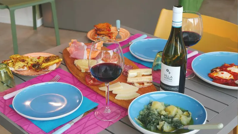 Une table est dressée avec des plats variés et des bouteilles de vin.