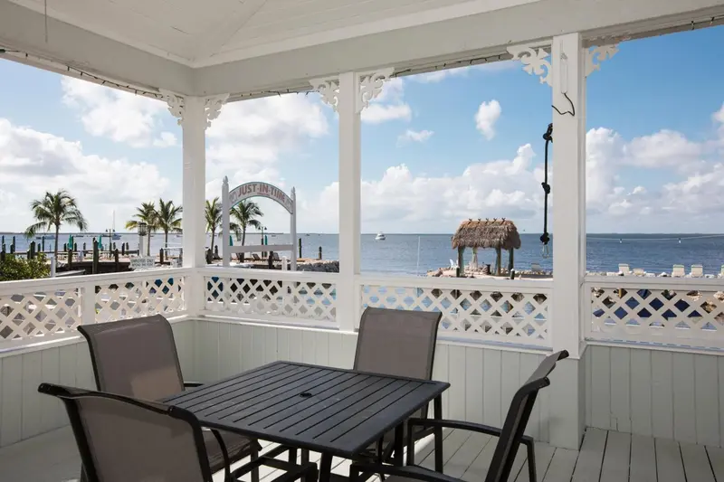 Terrasse ombragée avec mobilier de jardin donnant sur la mer.