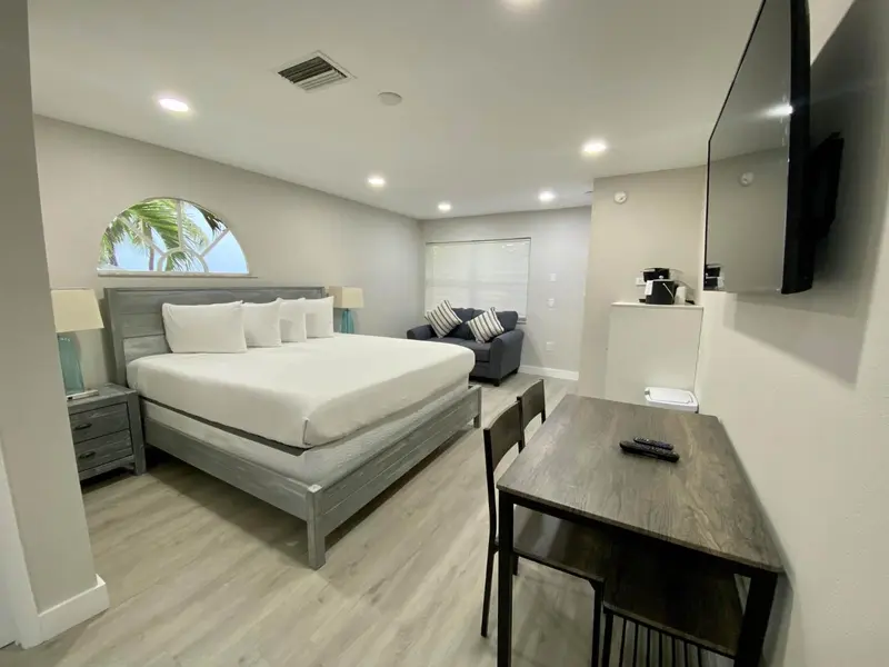 Une chambre lumineuse avec un grand lit et un espace bureau.