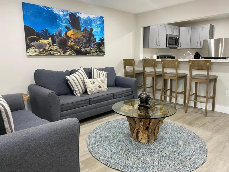 Un salon moderne avec canapé gris et table basse en bois.