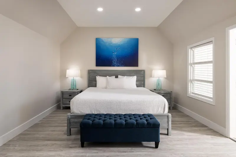 Une chambre lumineuse avec un grand lit et une décoration sobre.