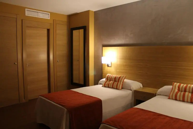 Chambre avec deux lits simples et une décoration chaleureuse.