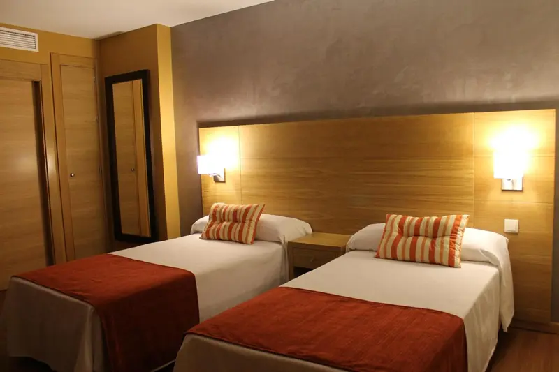 Une chambre avec deux lits simples et une décoration moderne.