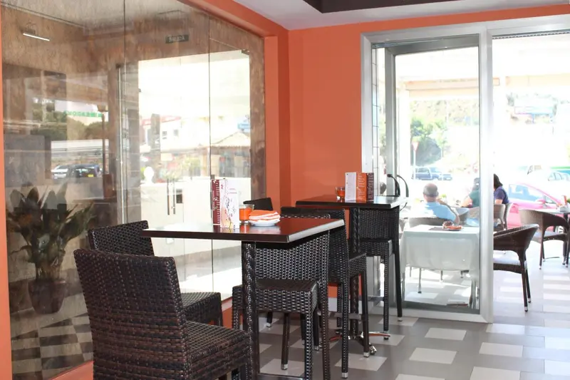 Une salle de restaurant avec des tables et des chaises en rotin.