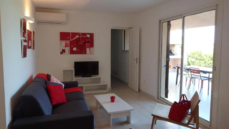 Un salon lumineux s'ouvre sur une terrasse avec mobilier d'extérieur.