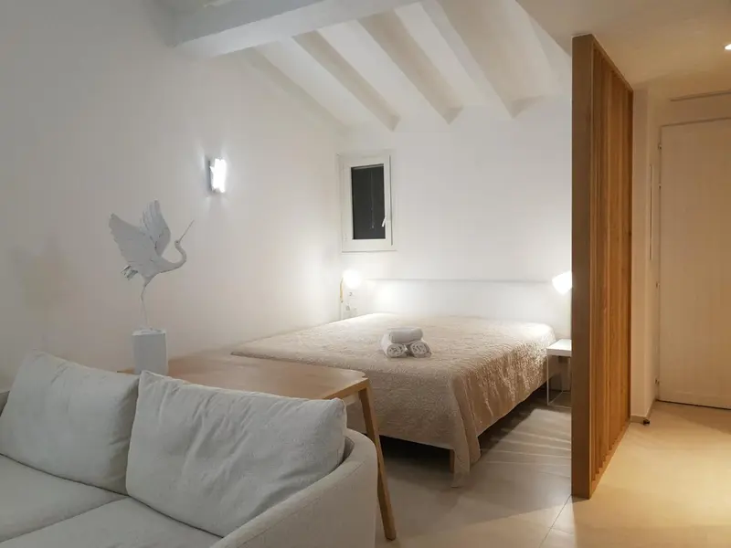 Une chambre lumineuse avec un lit et un canapé.