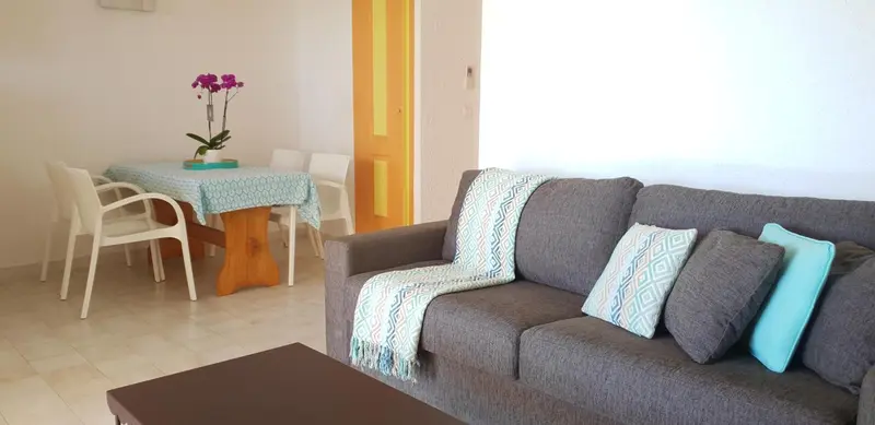 Un salon lumineux avec un canapé et une table à manger.