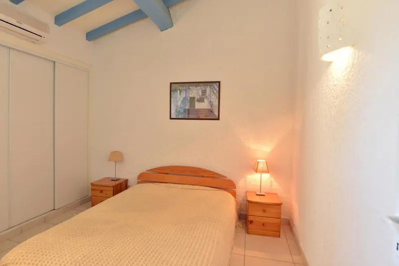 Une chambre lumineuse avec un lit simple et des meubles en bois.