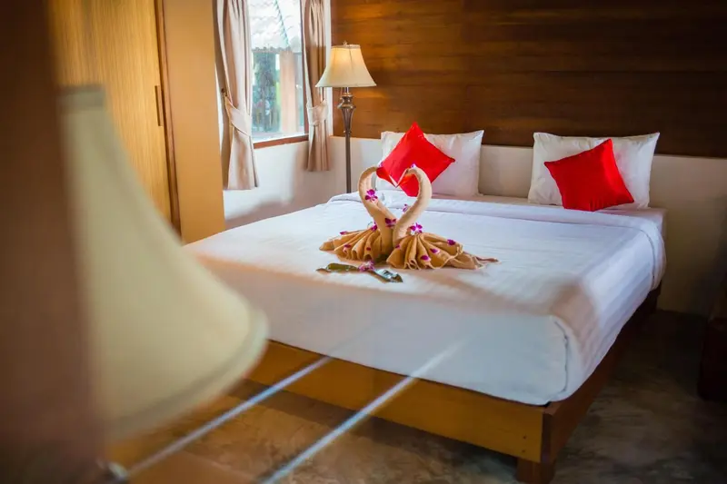 Une chambre lumineuse avec un lit soigneusement fait et des décorations florales.