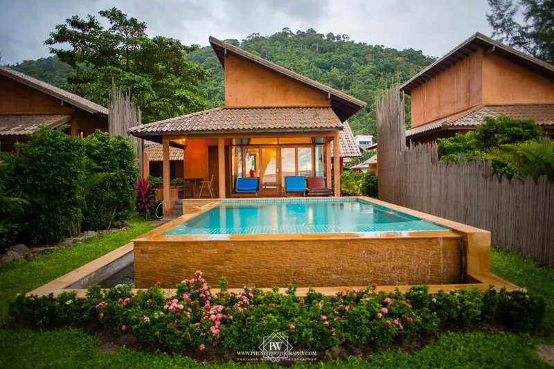 Petites maisons de vacances avec piscine privée et végétation luxuriante.