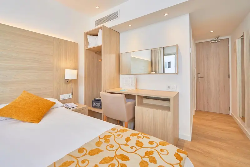 Une chambre lumineuse avec un lit et un espace bureau.