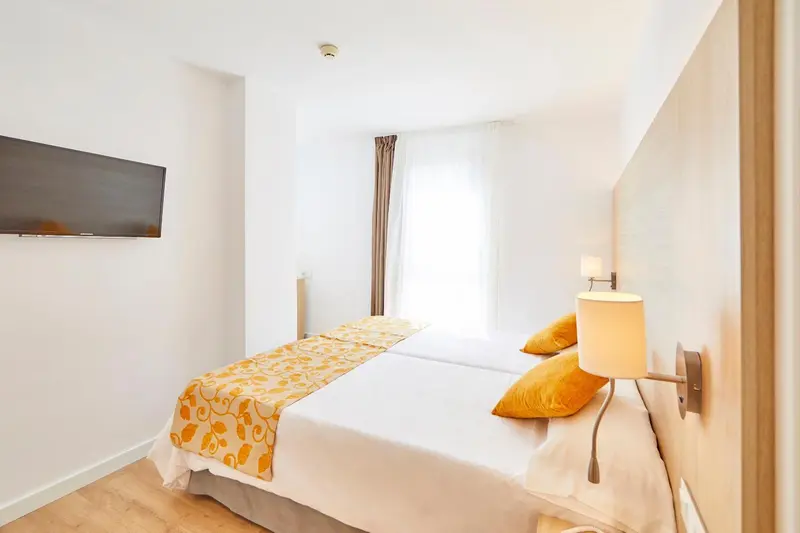 Une chambre lumineuse avec un lit double et une décoration sobre.