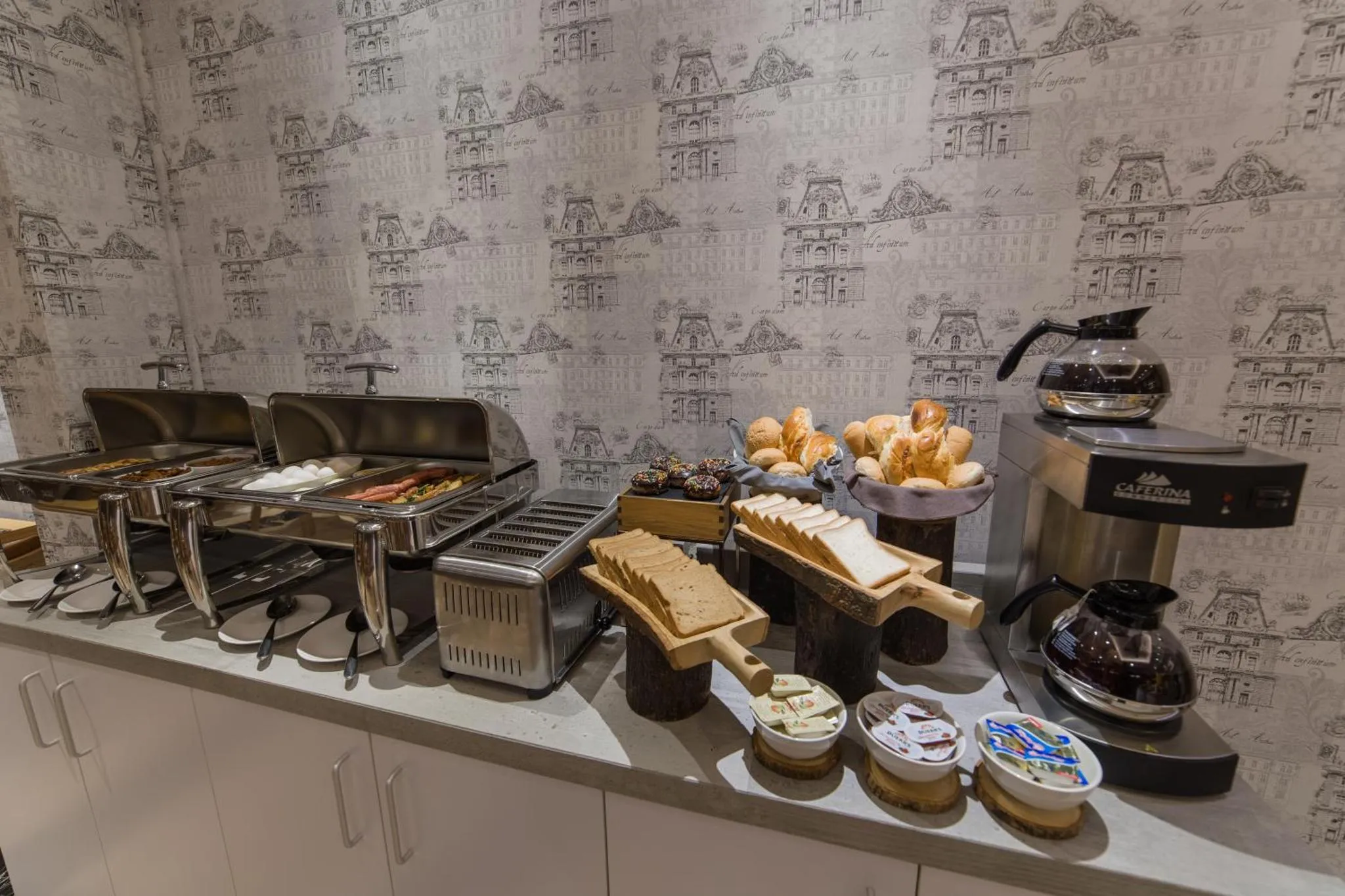 Un buffet propose des viennoiseries, des pâtisseries et des boissons chaudes.