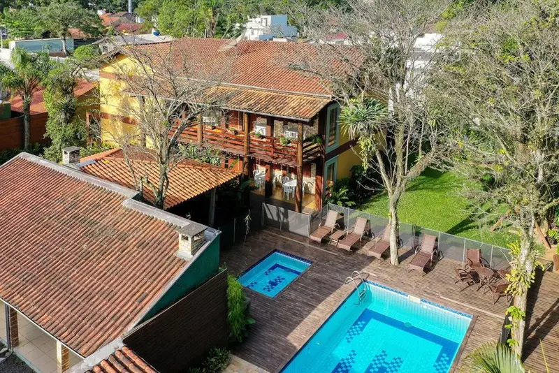 Vue aérienne d'un bâtiment avec une piscine et des chaises longues.