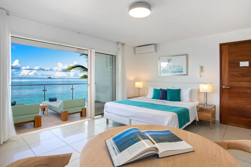 Une chambre lumineuse s'ouvre sur une terrasse avec vue sur la mer.