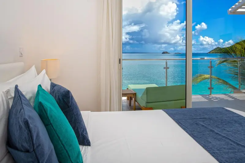 Une chambre lumineuse avec un lit confortable donnant sur une vue imprenable sur la mer.