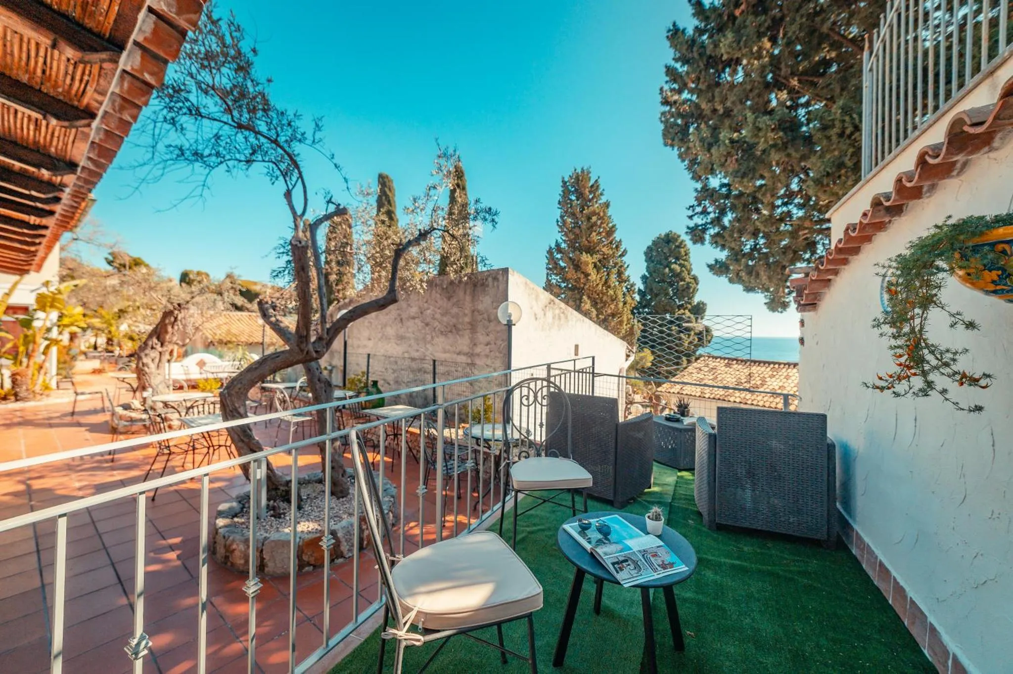 Terrasse carrelée avec mobilier d'extérieur et vue sur la mer.