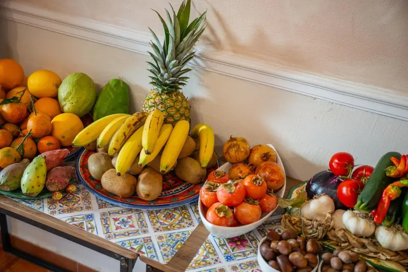 Une abondante composition de fruits frais et de légumes colorés est présentée sur une table décorée.