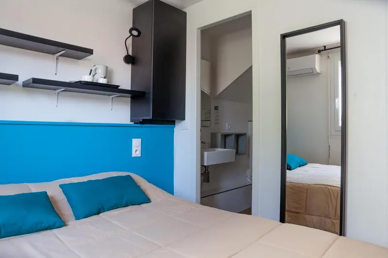 Une chambre lumineuse avec un lit et un miroir.