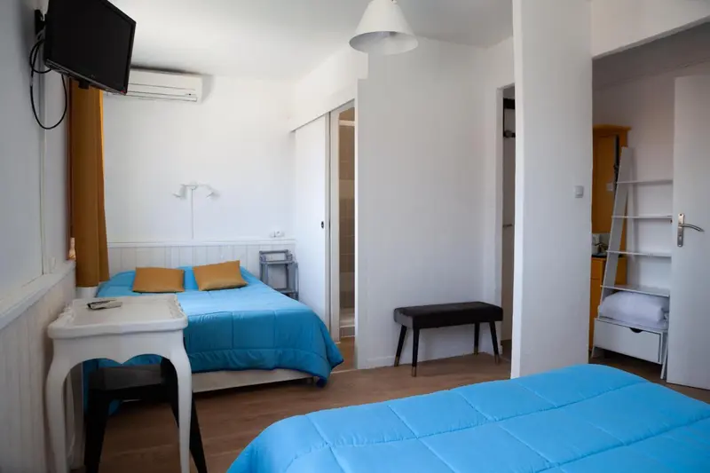 Une chambre lumineuse avec deux lits simples et un lit mezzanine.