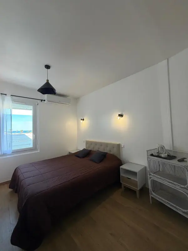 Une chambre lumineuse avec un grand lit et une vue sur la mer.