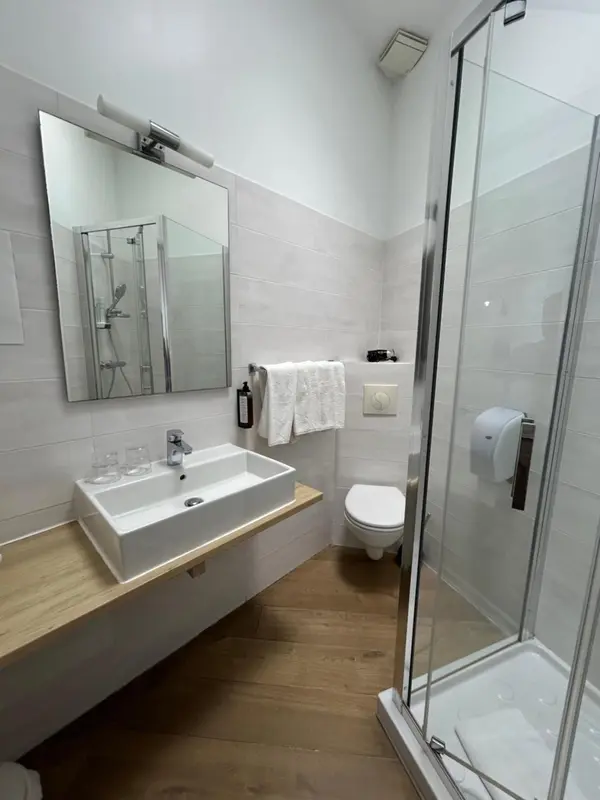 Une salle de bain moderne avec douche à l'italienne et vasque sur meuble.