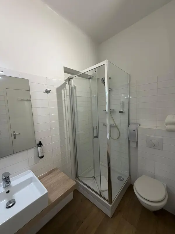 Une salle de bain moderne avec douche vitrée et lavabo.