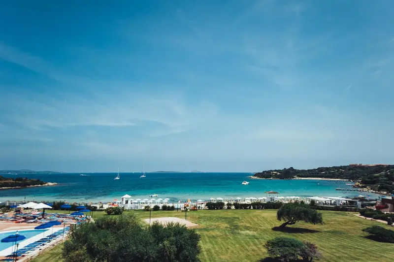 Vue d'une plage de sable fin bordée de parasols et de chaises longues.