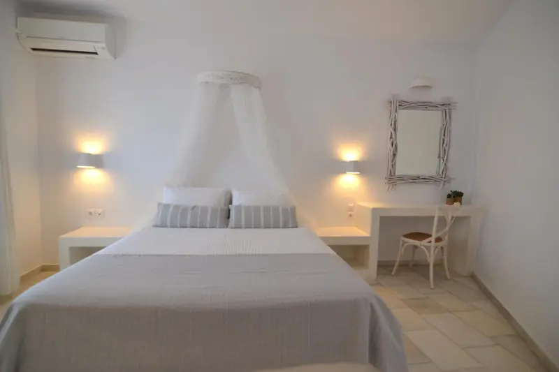 Une chambre lumineuse avec un lit à baldaquin et un bureau.