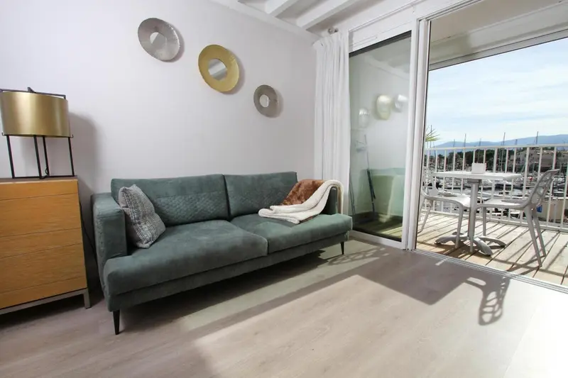 Un salon lumineux s'ouvre sur une terrasse avec vue sur le port.