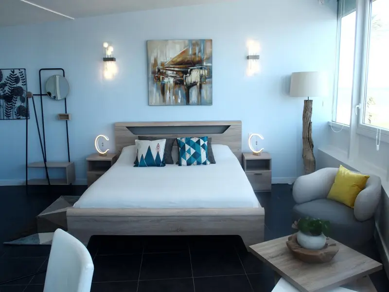 Une chambre lumineuse avec un grand lit et une décoration moderne.