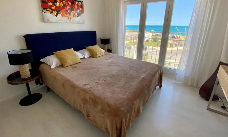 Une chambre lumineuse avec un grand lit et une vue sur la mer.