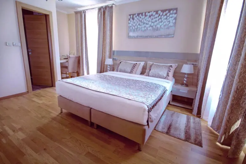 Une chambre lumineuse avec un grand lit et des rideaux décoratifs.