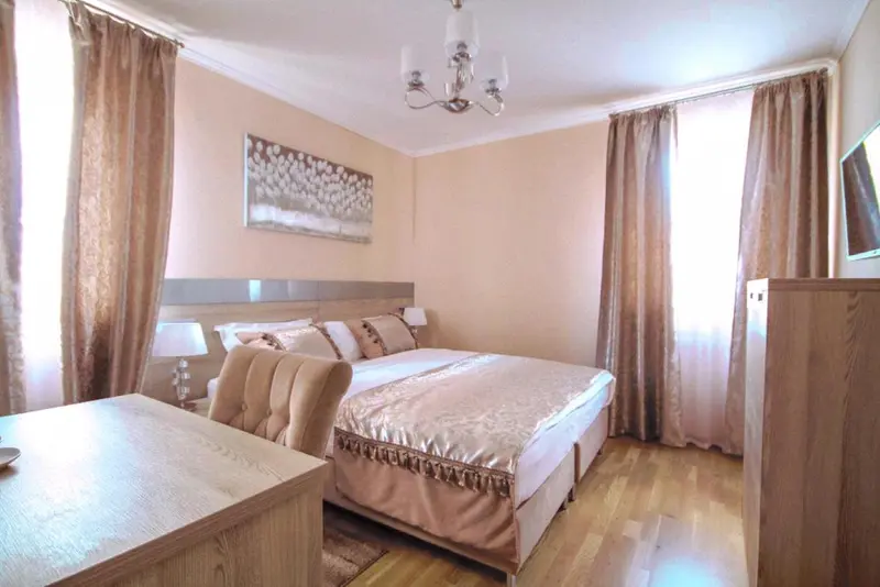 Une chambre lumineuse avec un grand lit et un décor sobre.