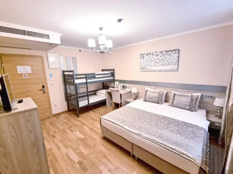 Une chambre avec un lit superposé et un grand lit double.