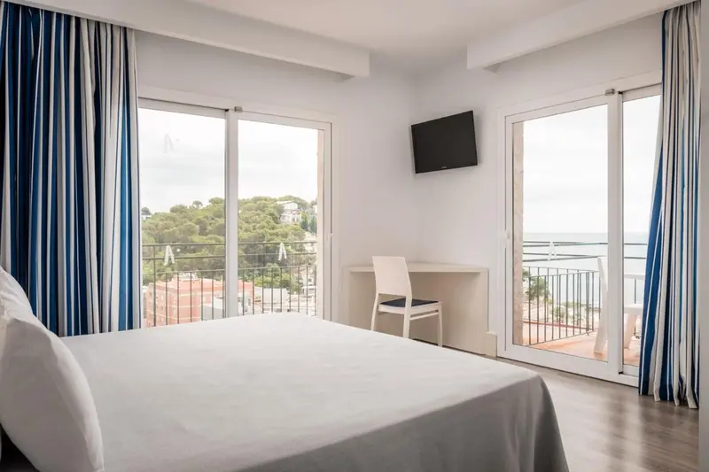Une chambre lumineuse avec un grand lit et une vue sur la mer.