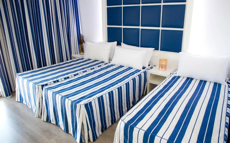 Une chambre lumineuse avec deux lits simples et une décoration marine.