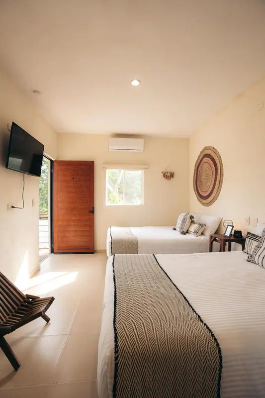 Une chambre lumineuse avec deux lits simples et une décoration murale.