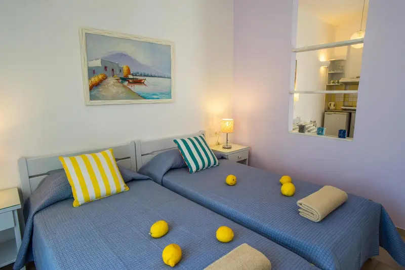 Une chambre lumineuse avec deux lits simples et une décoration murale.